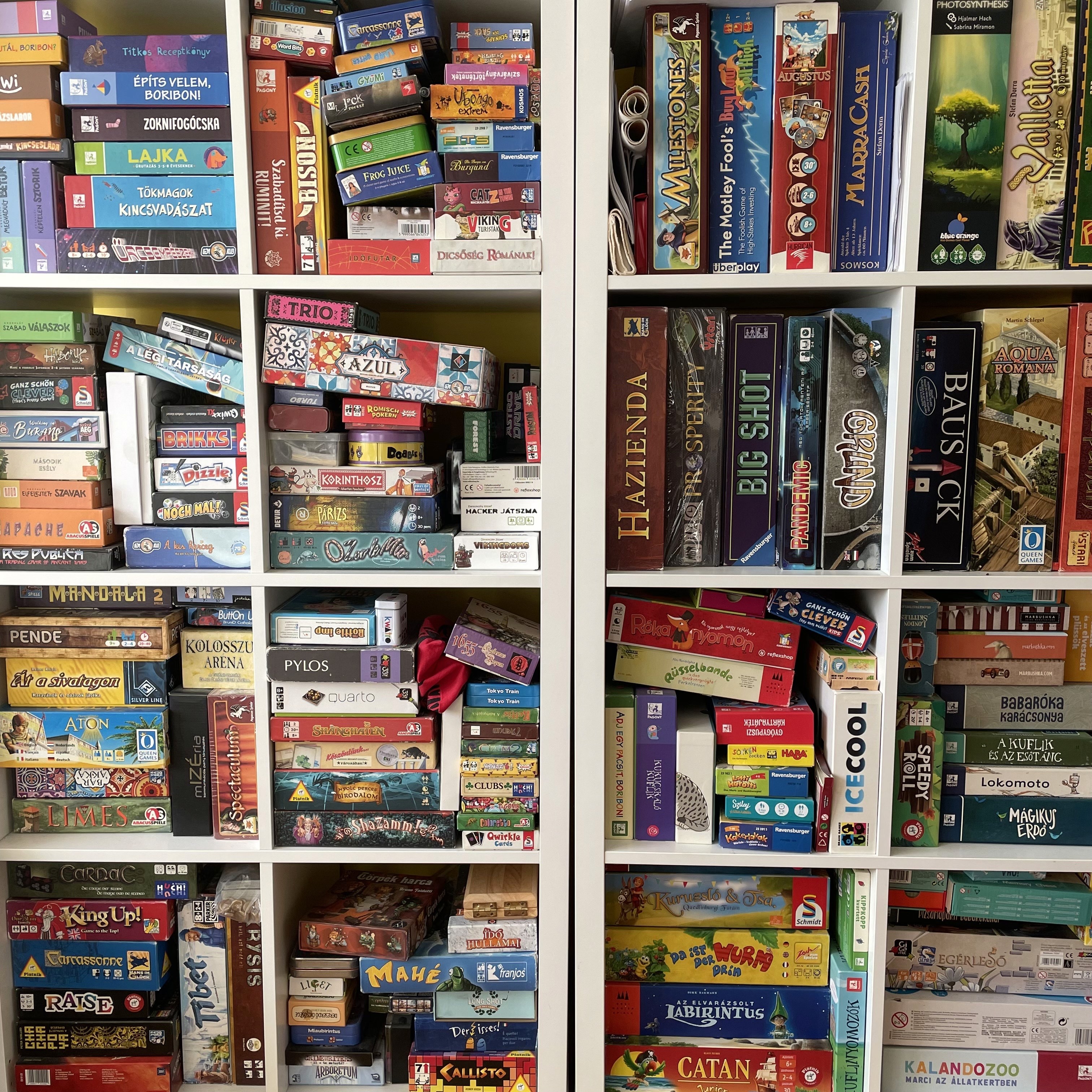One of the author's board game shelves showing various game boxes